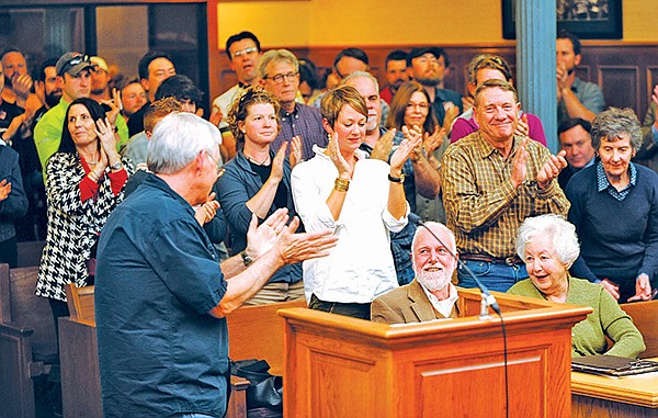 STAFF PHOTO ANDY SHUPE 
Bob Caulk, left, chairman of the Fayetteville Natural Heritage Association, leads a standing ovation Tuesday for Frank and Sara Sharp during a meeting of the City Council where the council voted to dedicate $1.5 million in partnership with the Fayetteville Natural Heritage Association and the Walton Family Trust to buy 376 acres atop Mount Kessler in southwest Fayetteville. Frank Sharp was instrumental in the effort to conserve the property.