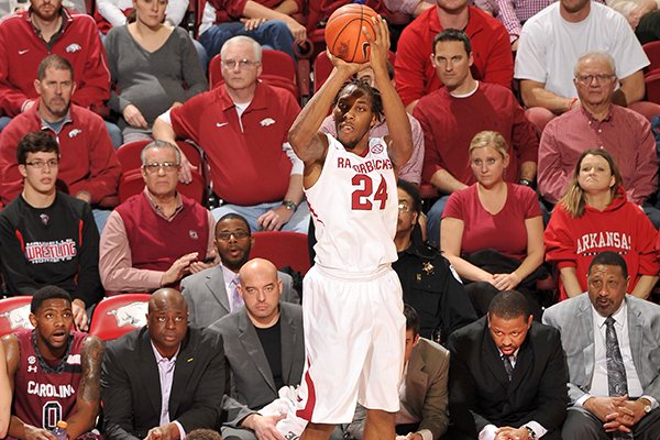 Arkansas guard Michael Qualls pulls up to hit a three-point shot over South Carolina defender Michael Careera during the first half of Wednesday's game at Bud Walton Arena in Fayetteville.