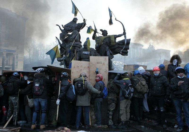 Anti-government protesters protected themselves with shields during clashes with riot police in Kiev's Independence Square, the epicenter of the country's current unrest, in Kiev, Ukraine, on Wednesday, Feb. 19, 2014. 