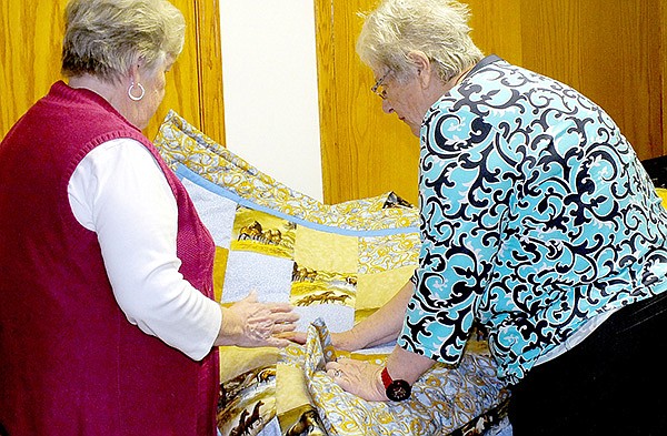 STAFF PHOTO CASSI LAPP
Sonja Ewing, left, and Granny’s Quilts of Love co-founder Mary Margaret Webb discuss a completed quilt.