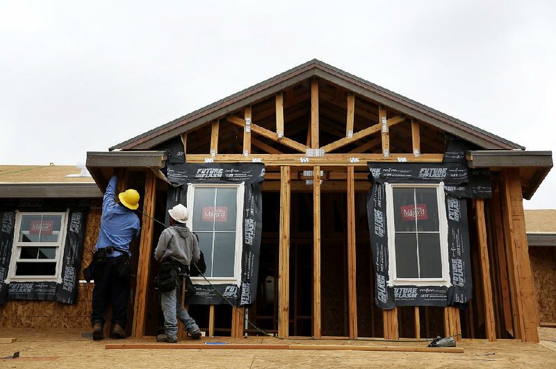 Contractors work last month on a new house in Irvine, Calif. Home construction fell in January for a second month, the Commerce Department said Wednesday. 