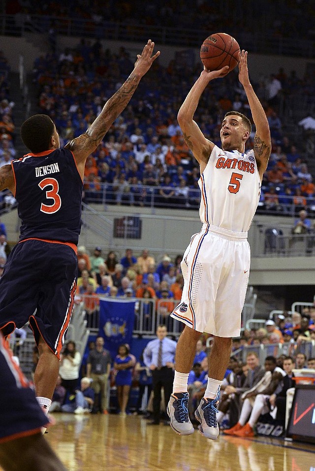 Florida’s Scottie Wilbekin (right) shoots a three-pointer as Auburn’s Chris Denson defends during the No. 2 Gators’ victory Wednesday night in Gainesville, Fla. 