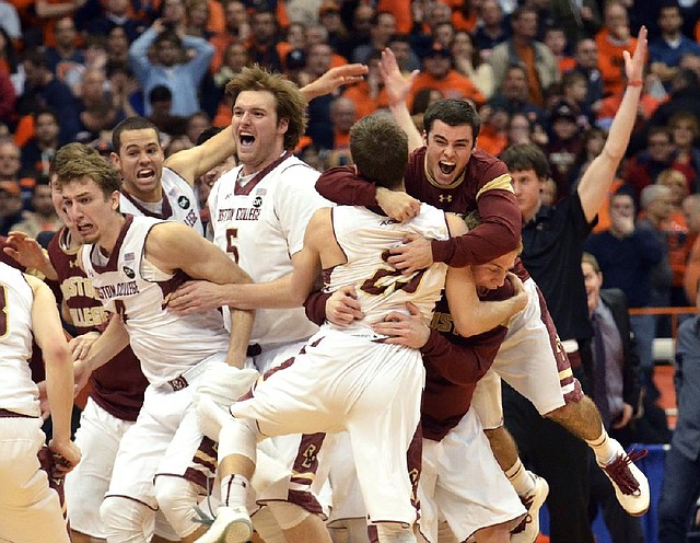 Boston College players celebrate after the Eagles’ 62-59 overtime victory Wednesday night in Syracuse, N.Y., over top-ranked Syracuse. 