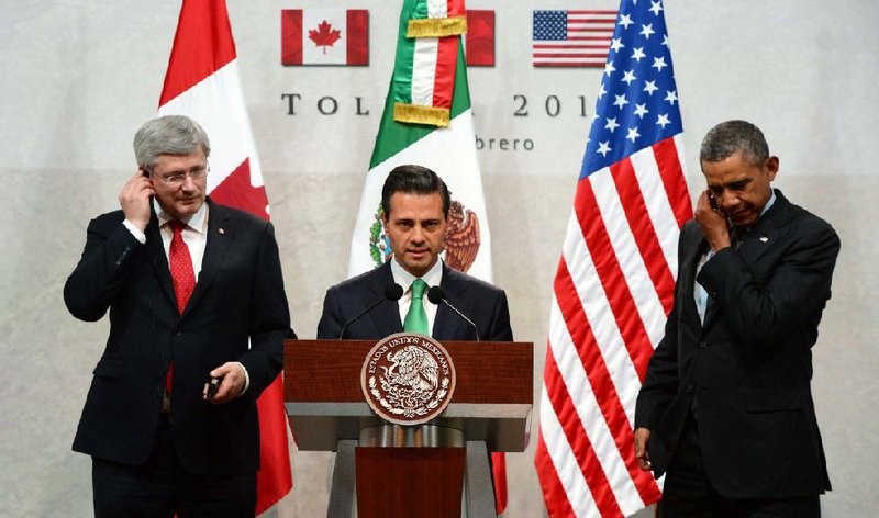 Canadian Prime Minister Stephen Harper (left) and President Barack Obama flank Mexican President Enrique Pena Nieto speaking Wednesday at a news conference during the North American Leaders Summit in Toluca, Mexico. 