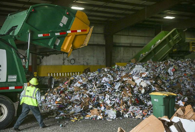 Driver Trudy Fowler watches as recyclables fall from her truck Wednesday morning at Waste Management’s Materials Recovery Facility on Sloane Drive in Little Rock. Little Rock Mayor Mark Stodola unveiled a plan Wednesday to expand the single-stream recycling program to multifamily dwellings. 