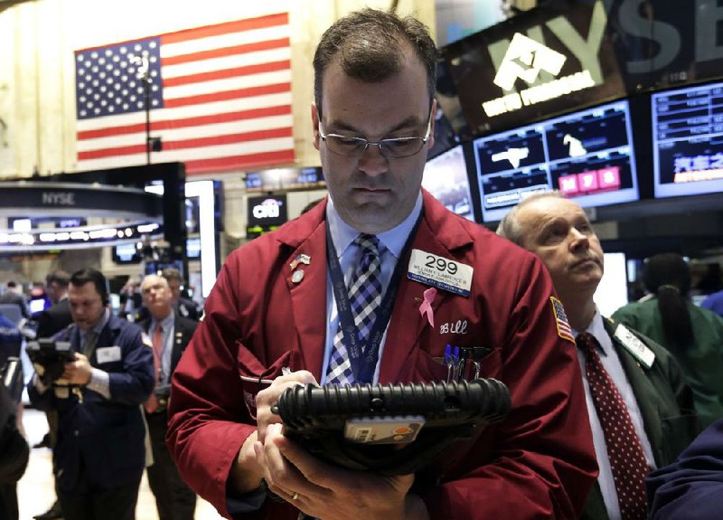 Trader William Lawrence works Wednesday on the floor of the New York Stock Exchange. Stocks prices fell as investors reacted to news that the Fed is willing to start raising short-term interest rates. 