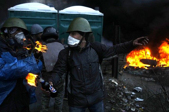 Anti-government protesters get ready to throw petrol bombs on the outskirts of Independence Square in Kiev, Ukraine, Thursday, Feb. 20, 2014. Fierce clashes between police and protesters, some including gunfire, shattered a brief truce in Ukraine's besieged capital Thursday, killing numerous people. The deaths came in a new eruption of violence just hours after the country's embattled president and the opposition leaders demanding his resignation called for a truce and negotiations to try to resolve Ukraine's political crisis.