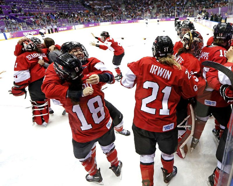 Team Canada celebrates after beating the USA 3-2 in overtime of the women's gold medal ice hockey game at the 2014 Winter Olympics, Friday, Feb. 21, 2014, in Sochi, Russia. (AP Photo/Mark Humphrey)