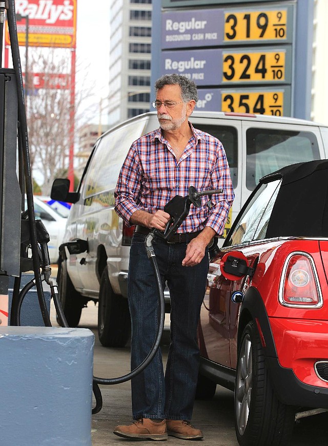 Arkansas Democrat-Gazette/RICK MCFARLAND --02/20/14--   Dom Yezzi cq, of North Little Rock, finishes gassing up his car at a Shell station, on Broadway at West 8th streets in Little Rock Thursday.