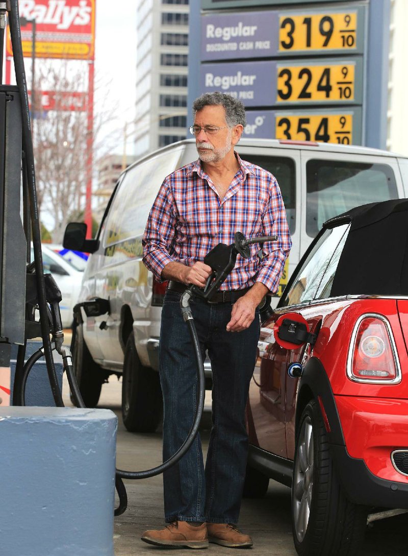 Arkansas Democrat-Gazette/RICK MCFARLAND --02/20/14--   Dom Yezzi cq, of North Little Rock, finishes gassing up his car at a Shell station, on Broadway at West 8th streets in Little Rock Thursday.