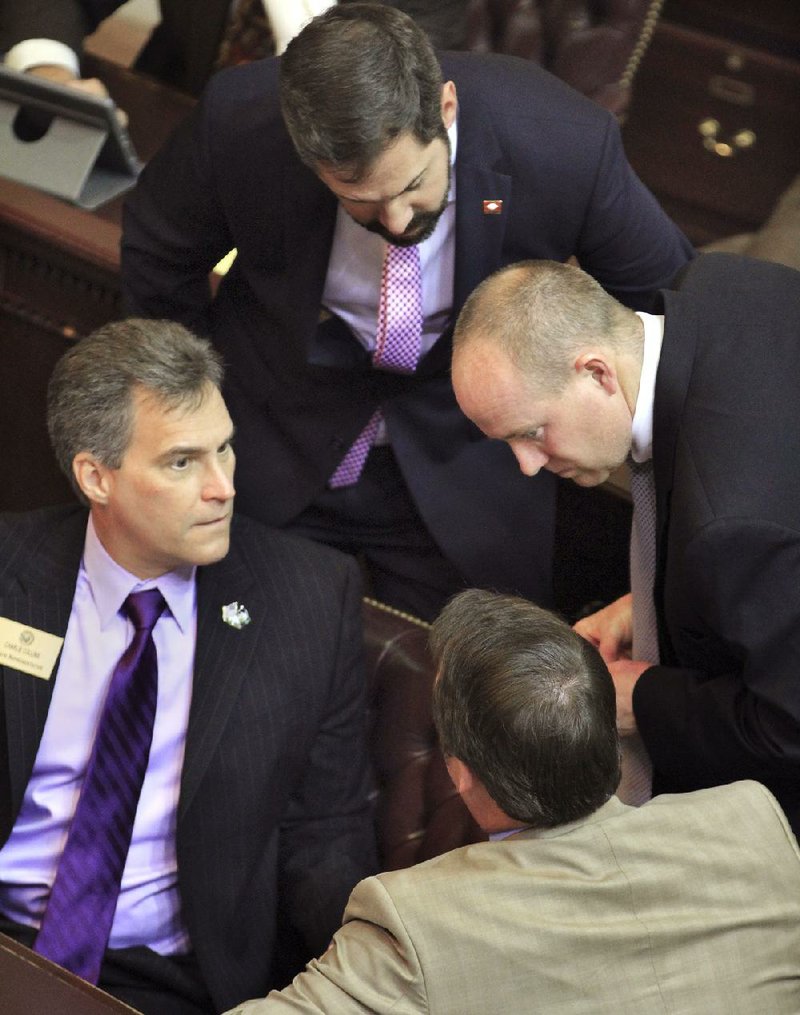 Arkansas Democrat-Gazette/BENJAMIN KRAIN --2/20/14--
Rep Charlie Collins, R-Fayetteville, left, House Minority Leader Greg Leding, D-Fayetteville, top, Jeff Wardlaw, D-Warren, right, and Rep John Burris, R-Harrison, discuss Burris's bill to fund private option Medicaid expansion in the House chamber Thursday afternoon at the State Capitol. The House again fell short of passing a funding bill to continue Arkansas's private option Medicaid expansion despite the Senate passing an identical bill earlier in the day. The House voted 72-25 in favor of House Bill 1150, marking the third time in as many days it has failed to reach the required 75-vote supermajority threshold for passage.The private option plan allows the state to buy private insurance for Arkansans with incomes of up to 138 percent of the poverty level using federal Medicaid money.