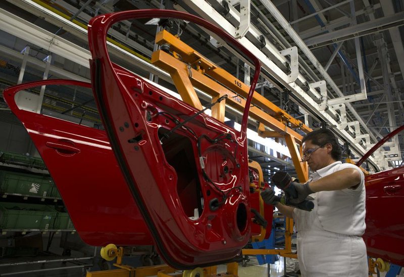 An employee works on a door for a Volkswagen AG Jetta last month at the company’s plant in Puebla, Mexico. Auto manufacturing is a large part of Mexico’s industrial boom. 