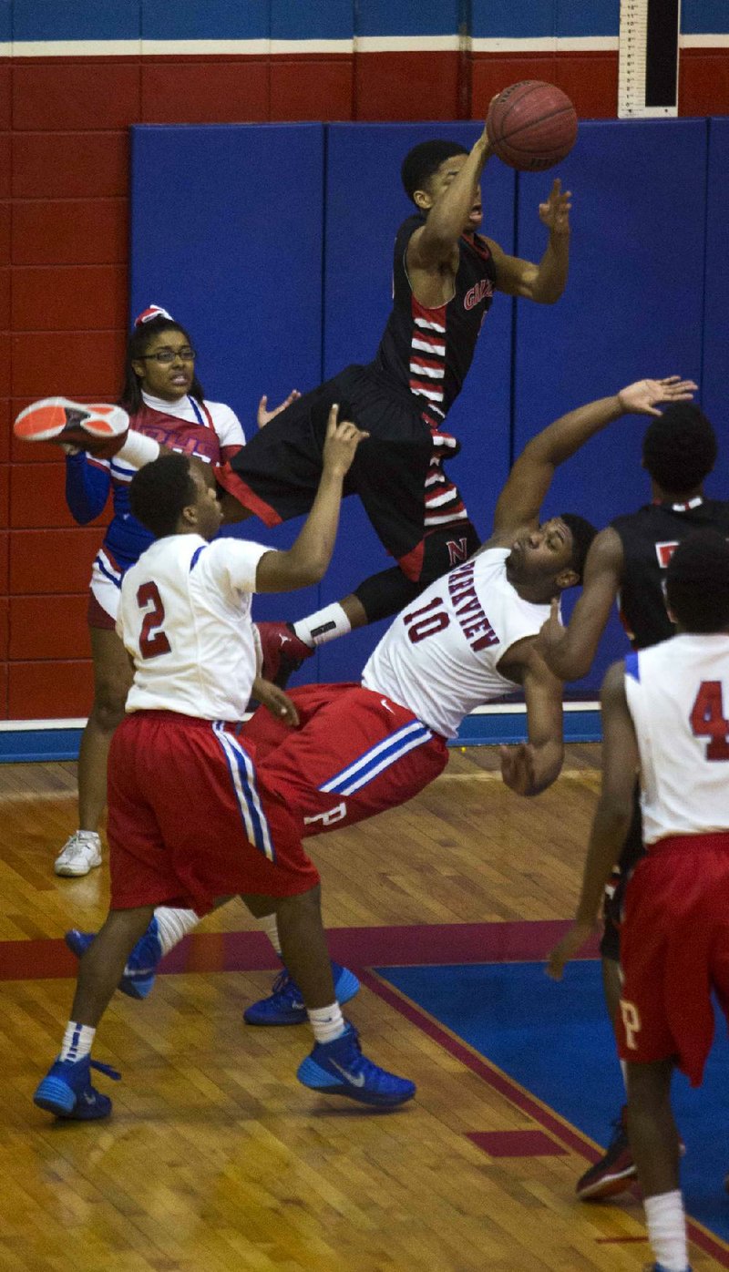 Fort Smith Northside’s TJ Whitmore (middle) looks to pass in midair while being guarded by Little Rock Parkview’s Ryan Pippins (10) and Darius Elliot during the Grizzlies’ 61-40 loss Friday night at Ripley Arena. 