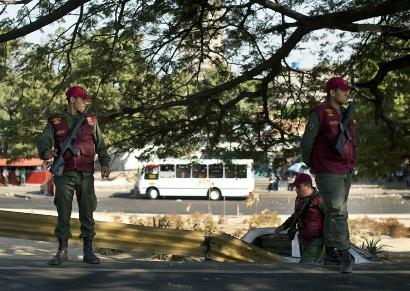 Bolivarian National Guard officers stand guard next to the highway through which the funeral procession of Genesis Carmona passed in Valencia, Venezuela, Friday, Feb. 21, 2014. Carmona a university student and beauty queen who was slain during a political protest on Feb.18 in Valencia, was buried Friday, a victim of what government opponents say is the kind of indiscriminate violence that has been used to stifle dissent across the country by supporters of President Nicolas Maduro. (AP Photo/Rodrigo Abd)