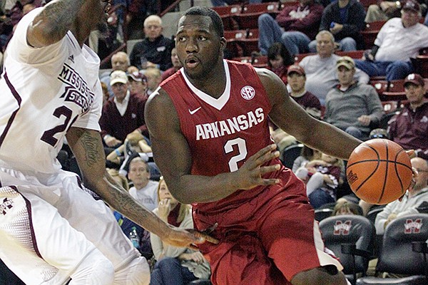 Arkansas' Alandise Harris (2) drives past Mississippi State's Roquez Johnson, left, during the first half of an NCAA college basketball game in Starkville, Miss., Saturday, Feb. 22, 2014. (AP Photo/Jim Lytle)