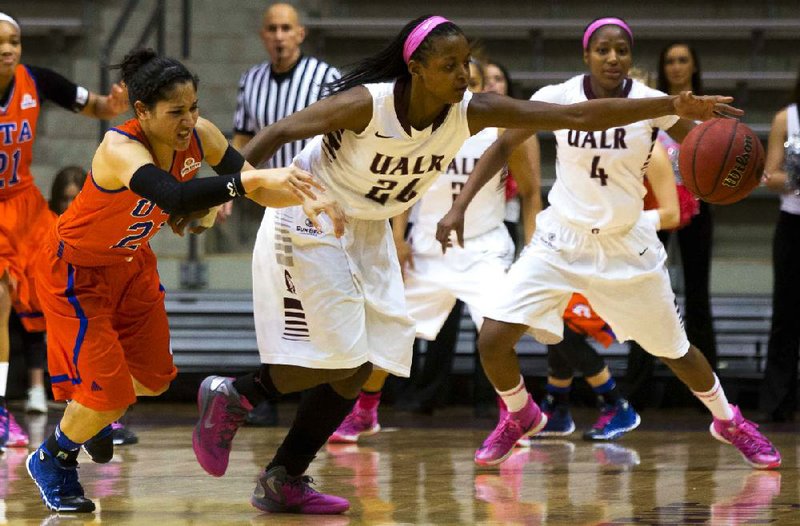 UALR’s Taylor Gault (center) chases a loose ball along with Texas-Arlington’s Laila Suleiman on Saturday afternoon at the Jack Stephens Center in Little Rock. Gault scored 29 points in the Trojans’ 69-60 victory. 