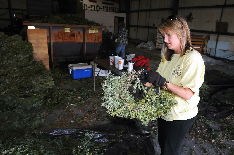 STAFF PHOTO SAMANTHA BAKER w @NWASAMANTHA
Jill Jackson, a volunteer with Bo's Blessings and sister of Bo Swearingen, tears greenery off wreaths Saturday, Feb. 22, 2014, at a warehouse in Fayetteville. Volunteers were breaking down approximately 6,000 wreaths collected from the Fayetteville National Cemetery to be recycled. Money collected from the wreaths' wire sold to the city's recycling center will be used to help the cemetery purchase more land.