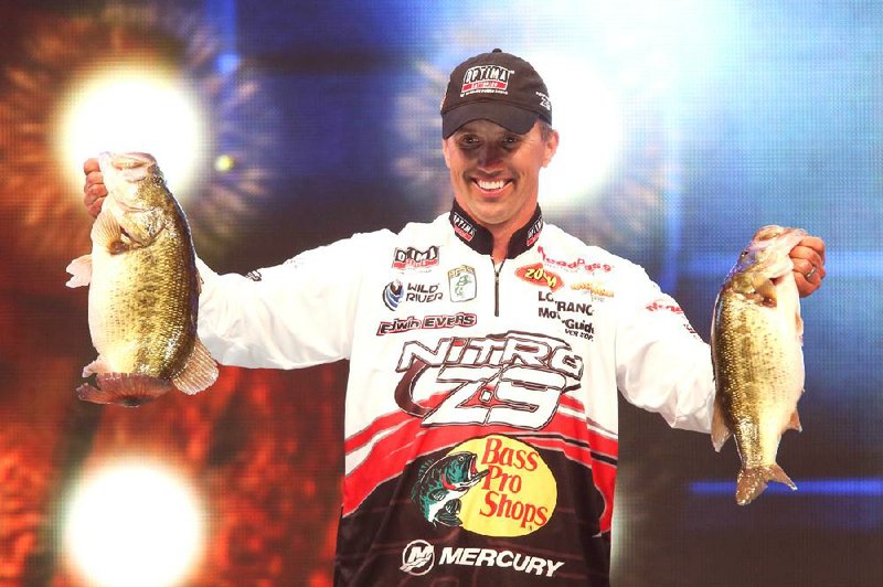 Edwin Evers of Talala, Okla., shows off two of the five bass he caught that left him with a one-ounce lead through two days of the Bassmaster Classic on Lake Guntersville, Ala. 