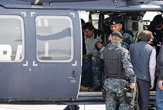 Drug lord Joaquin “El Chapo” Guzman sits handcuffed inside a Mexican federal police helicopter Saturday in Mexico City after his capture. 