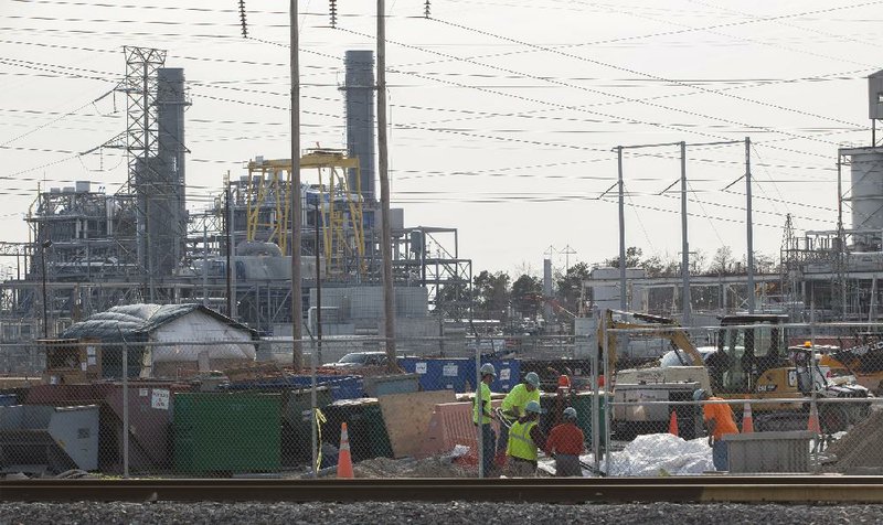 Men work at the L.V. Sutton Complex operated by Duke Energy in Wilmington, North Carolina on Wednesday, Feb. 19, 2014. Members of the Flemington Road community near the plant feel the facility could be polluting well water with spill off and seepage from large coal ash ponds.   (AP Photo/Randall Hill) 