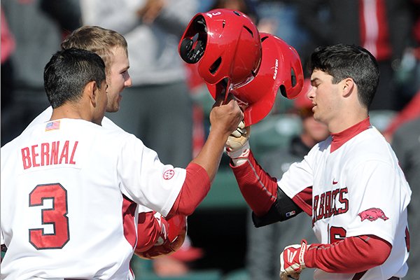 Arkansas' Michael Bernal, from left clockwise, and Bobby Wernes congratulate Andrew Benintendi on his home run Sunday, Feb. 23, 2014, while crossing home plate during the game against Eastern Illinois at Baum Stadium in Fayetteville.