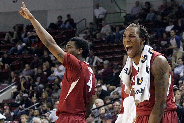 Arkansas' Coty Clarke (4) and Michael Qualls, right, celebrate during the second half of an NCAA college basketball game against Mississippi State in Starkville, Miss., Saturday, Feb. 22, 2014. (AP Photo/Jim Lytle)