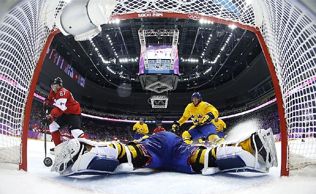 Canada forward Sidney Crosby scores a goal on Sweden goaltender Henrik Lundqvist during the second period of the men's gold medal ice hockey game at the 2014 Winter Olympics, Sunday, Feb. 23, 2014, in Sochi, Russia. (AP Photo/Julio Cortez, Pool)