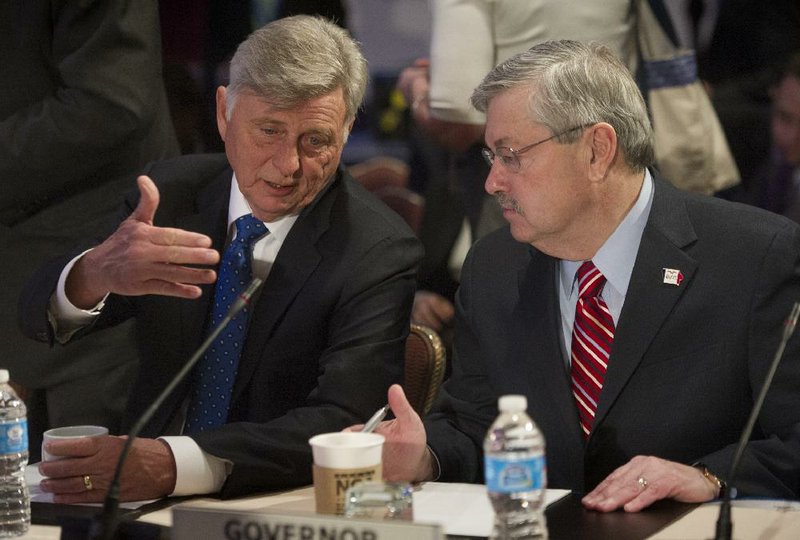 Arkansas Gov. Mike Beebe, left, talks with Iowa Gov. Terry Branstad during the National Governor's Association Winter Meeting's special session on jobs in America, in Washington, Sunday, Feb. 23, 2014. (AP Photo/Cliff Owen)