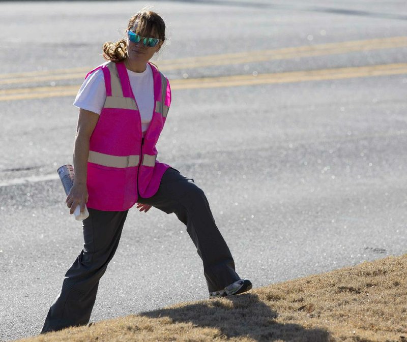 Arkansas Democrat-Gazette/MELISSA SUE GERRITS 02/22/2014 - Gina Pharis, executive director of the LIttle Rock Marathon watches for traffic while marking an aid station on the marathon's route along Cantrell February 22, 2014. 