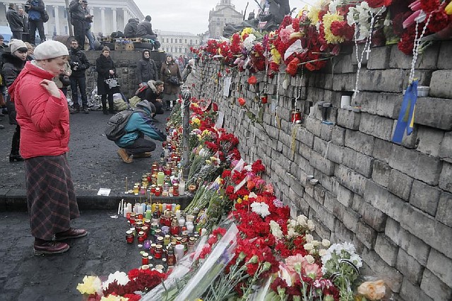 People lay flowers and lit candles at one of the barricades heading to Kiev's Independence Square, the epicenter of the country's recent unrest, Ukraine, on a mourning day  Sunday, Feb. 23, 2014. Official reports say 82 people were killed in severe clashes between opposition activists and riot police.  A top Ukrainian opposition figure assumed presidential powers Sunday, plunging Ukraine into new uncertainty after a deadly political standoff  and boosting long-jailed Yulia Tymoshenko's chances at a return to power.(AP Photo/Efrem Lukatsky)