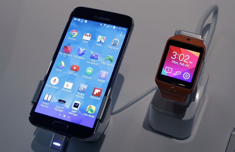 A Samsung Galaxy S5 smartphone, left, and a Samsung Gear 2 are displayed at the Samsung Galaxy Studio, in New York on Monday. Samsung on Monday unveiled a new smartphone with a built-in heart rate monitor to complement three upcoming fitness devices, as the Korean company tries to turn its technological wizardry into lifestyle products