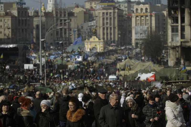 People flock to the Independence Square in Kiev, Ukraine, on Monday, Feb. 24, 2014. Ukraine's acting government issued a warrant Monday for the arrest of President Viktor Yanukovych, last reportedly seen in the pro-Russian Black Sea peninsula of Crimea, accusing him of mass crimes against protesters who stood up for months against his rule.