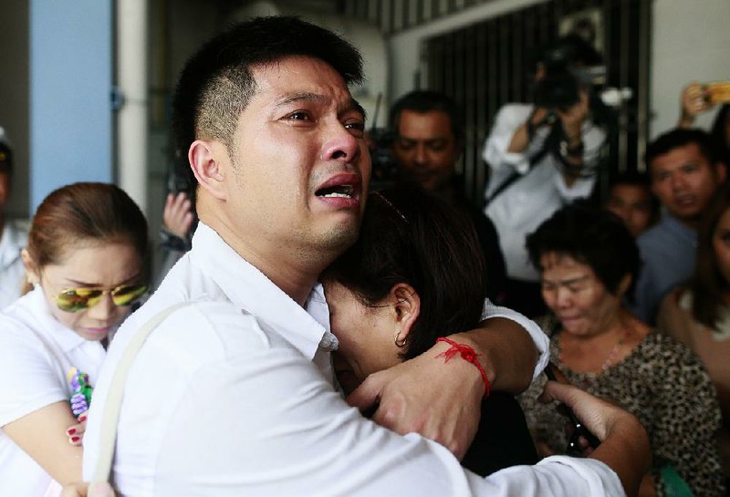 Tayakorn Yos-ubon, left, and Noppawan Chairat, right, the parents of two children killed in Sunday's bomb attack on an anti-government protest site, embrace each other as they wait for their children's bodies at a hospital in Bangkok Monday, Feb. 24, 2014. Two young siblings, 6-year-old girl Patcharakorn and her 4-year-old brother Korawit, along with another woman were killed in an apparent grenade attack against anti-government protesters occupying an upscale shopping area of Thailand's capital on Sunday, the latest violence in a months-long political crisis that is growing bloodier by the day. (AP Photo/Wason Wanichakorn)