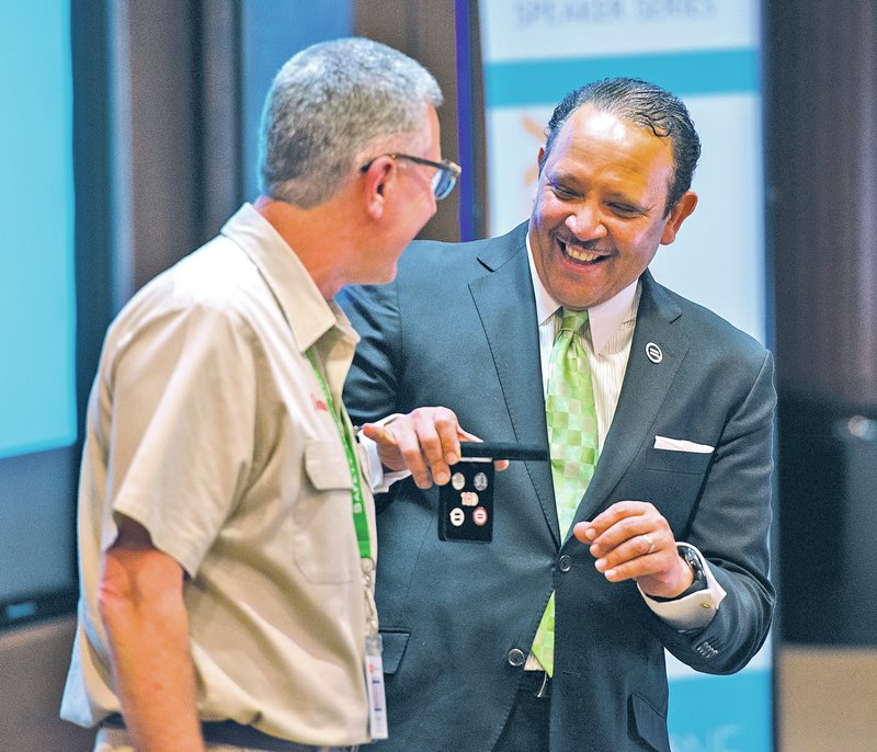 STAFF PHOTO ANTHONY REYES 
Donnie Smith, left, Tyson Foods’ president and CEO, laughs Monday with Marc Morial, CEO of the National Urban League, as Morial presents Smith with a set of lapel pins at Tyson Foods’ World Headquarters in Springdale. Morial gave a speech at the Tyson Diversity Education Speaker series.