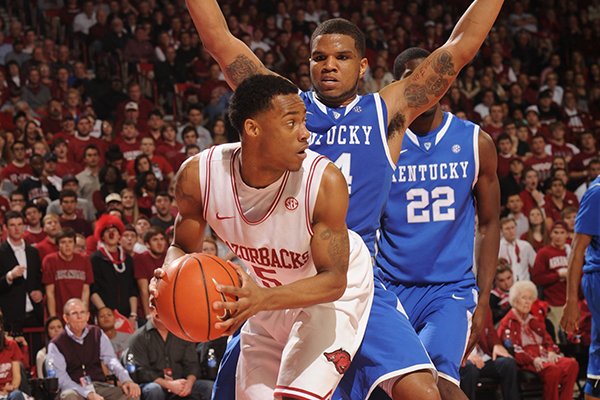 Arkansas guard Anthlon Bell (5) looks to pass out of a trap as Kentucky guard Julius Mays during the second half of play Saturday, March 2, 2013, in Bud Walton Arena in Fayetteville.