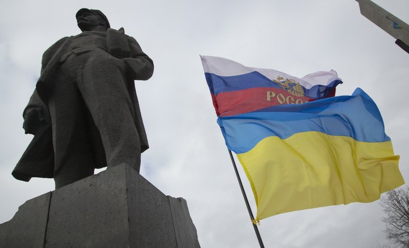 The Russian and Ukrainian flags fly, next to the statue of Vladimir Ilyich Lenin, in Donetsk, eastern Ukraine, on Tuesday, Feb. 25, 2014. The Ukrainian parliament on Tuesday delayed the formation of a new government, reflecting political tensions and economic challenges following the ouster of the Russia-backed president. 