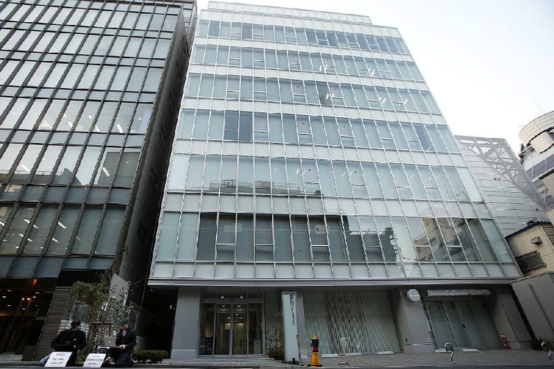 Mt. Gox customers (left) sit Tuesday in protest outside a building housing the company’s Tokyo headquarters. Mt. Gox, one of the largest bitcoin exchanges, seemingly shut down Tuesday without notice. 