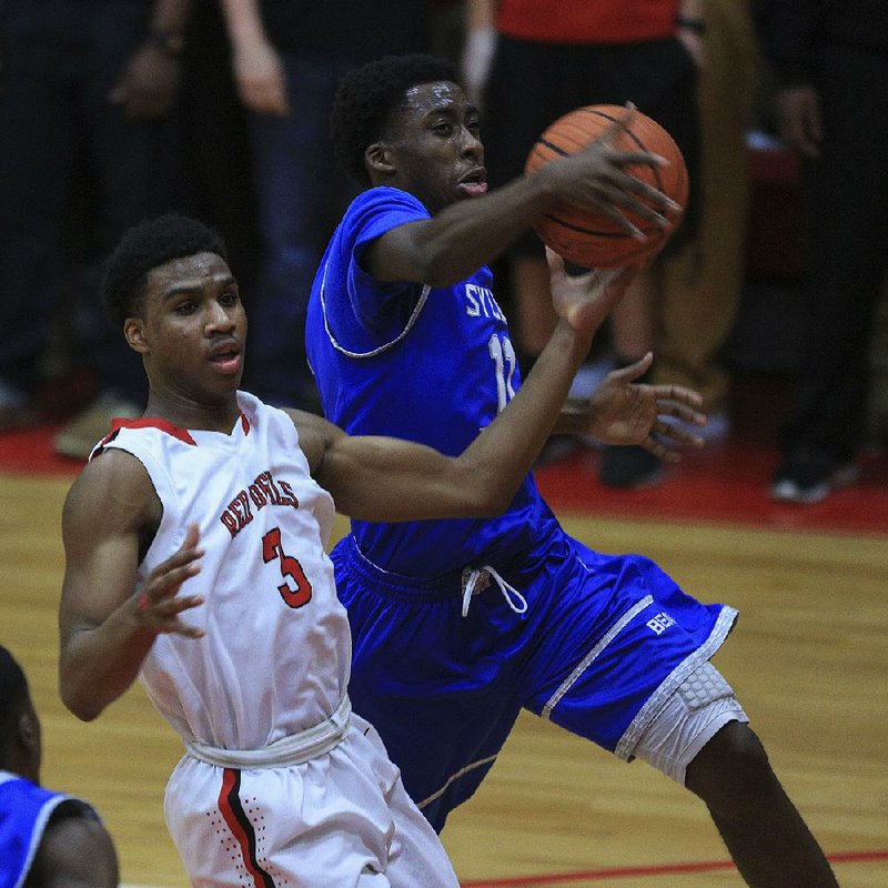 Aumonie Armond (right) of Sylvan Hills and Jacksonville’s Devin Campbell go after a loose ball during Tuesday night’s game in Jacksonville. 