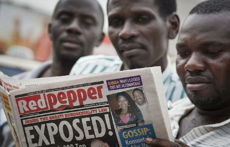 Ugandans read a copy of the Red Pepper tabloid newspaper Tuesday in Kampala, Uganda. A list of what it called the country’s “200 top” homosexuals was published, outing some Ugandans who previously had not identified themselves as gay, one day after President Yoweri Museveni signed a harsh anti-gay law into effect. 