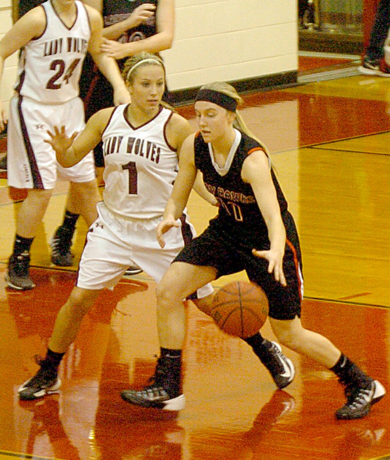 Mark Humphrey NWA Media Pea Ridge junior Mikheala Cochran drives with a left-handed dribble against the defense of Lincoln's Shelby Rowe. Cochran scored 5 points in the Blackhawks' 46-38 loss to Lincoln in the first-round of the District 4A-1 girls basketball tournament at Farmington on Feb. 18.