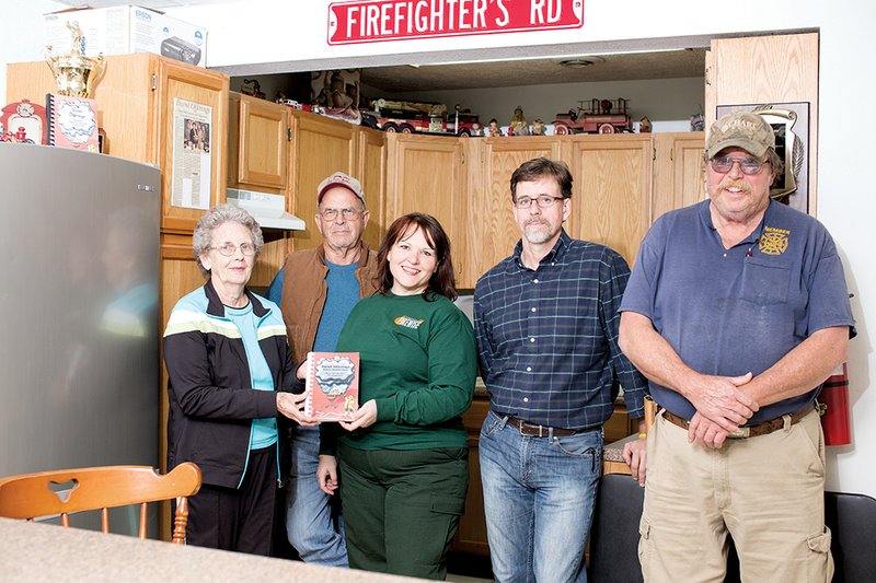 Members of the Cherry Hill Volunteer Fire Department, from the left, Sheila Doughty, Jarrell Payne, Shelby Bull, Troy Glenn and Bernard Bull show off their new cookbook, Burnt Offerings, Silver Anniversary, that they have published to help raise money for the Fire Department.