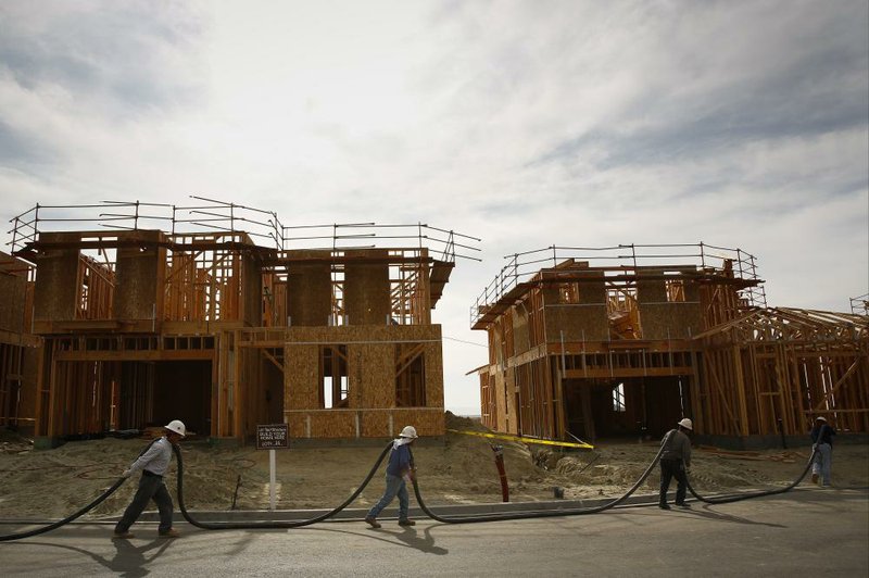 Workers carry a hose to pump concrete for a retaining wall at the Baker Ranch development in Lake Forest, Calif., earlier this month. Sales of new homes posted gains in January. 