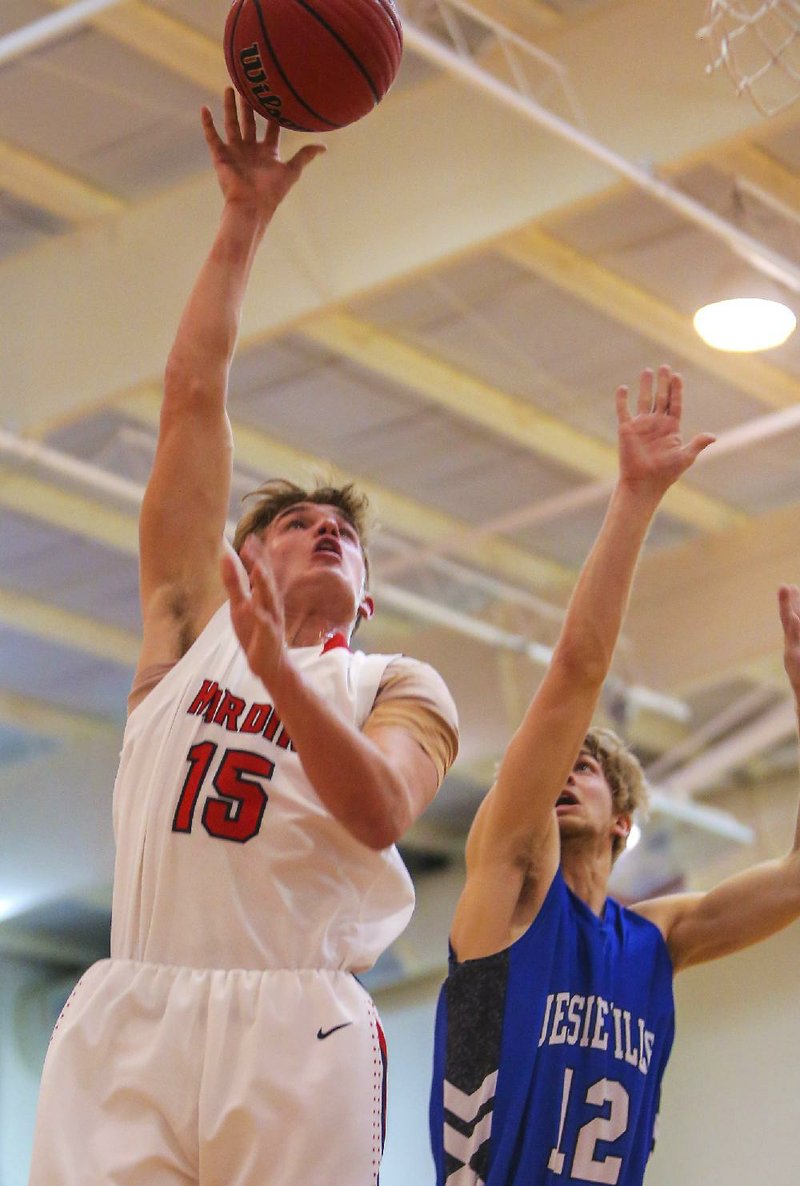 Harding Academy’s Kohl Blickenstaff (15) puts up a shot in front of Jessieville’s Kenton Polk (12) during the Wildcats’ 54-43 victory over the Lions on Wednesday at the Class 3A Region 2 tournament in Haskell. 