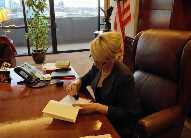 Arizona Gov. Jan Brewer puts her veto on a state Senate bill that thrust Arizona into the national spotlight in this photo tweeted by her office. She said the broadly worded bill “could divide Arizona in ways we could not even imagine, and no one would ever want.” 