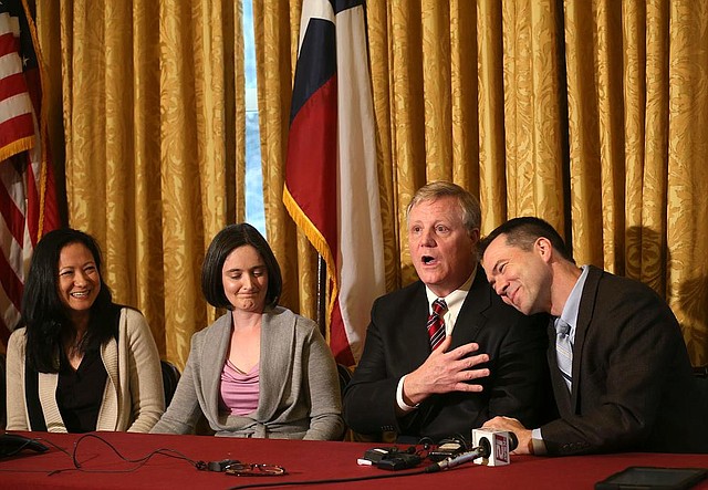 Cleopatra De Leon (from left), Nicole Dimetman, Mark Phariss and Victor Holmes hold a news conference Wednesday in San Antonio after a judge declared the state’s ban on same-sex marriage unconstitutional. The gay couples had filed lawsuits over the ban. The law remains in effect pending an appeal. 