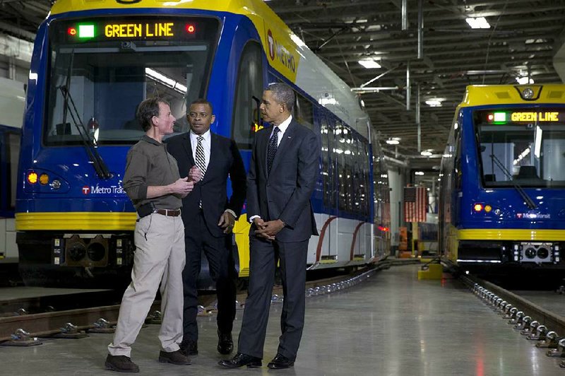 Mark Fuhrmann (left), a metro transit official in St. Paul, Minn., talks with Transportation Secretary Anthony Foxx and President Barack Obama during a tour of the city’s light-rail center Wednesday. 