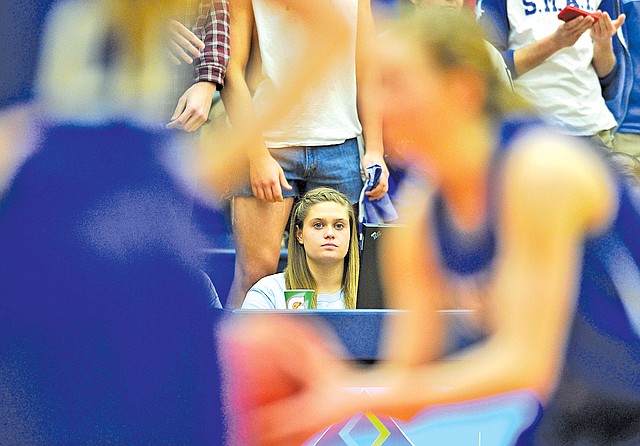  Staff Photo Michael Woods • @NWAMICHAELW Alex Moisson, Rogers senior forward, watches the Lady Mounties play against Rogers Heritage on Tuesday as she helps keep stats from the sidelines at Rogers Heritage.