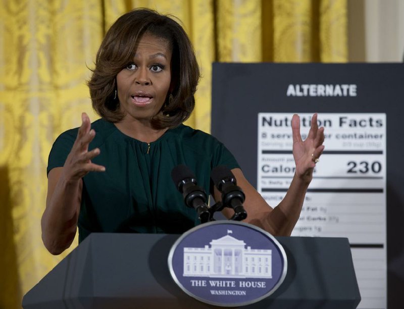 First lady Michelle Obama gestures as she speaks in the East Room of the White House in Washington, Thursday, Feb. 27, 2014, about helping parents and other consumers make healthier choices as part of her Let's Move program. The Obama administration is proposing new food labels that would make it easier to know about calories and added sugars, a reflection of the shifting science behind nutrition.  (AP Photo/Carolyn Kaster)