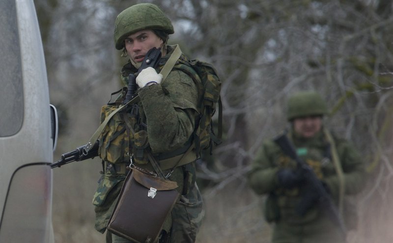 An unidentified gunman uses his radio while he and others block the road toward the military airport at the Black Sea port of Sevastopol in Crimea, Ukraine, on Friday, Feb. 28, 2014. Russian troops took control of the two main airports in the strategic peninsula of Crimea, Ukraine's interior minister charged Friday, as the country asked the U.N. Security Council to intervene in the escalating conflict. Russian state media said Russian forces in Crimea denied involvement. 