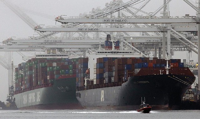 Container ships wait to be unloaded in the Port of Oakland in California in late October. The Commerce Department said Friday that the U.S. economy in the fourth quarter expanded at a slower pace than initially estimated. 